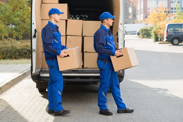 Homens de entrega transportando caixas de papelão — Fotografia de Stock