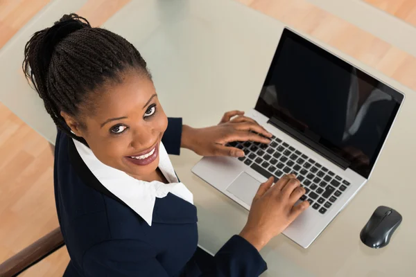 Leende ung affärskvinna med laptop — Stockfoto