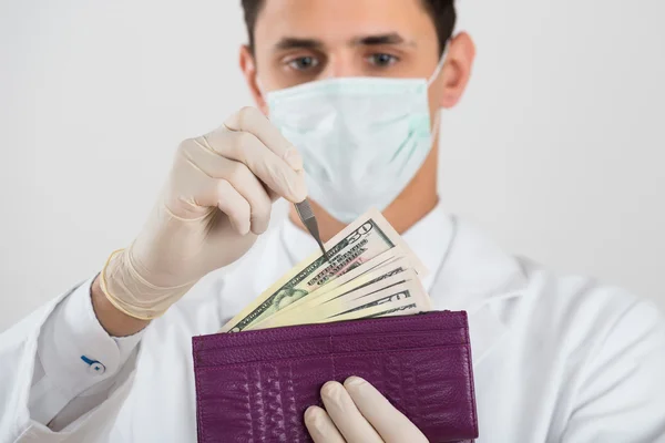 Kirurgfjerner seddel fra lommeboken – stockfoto
