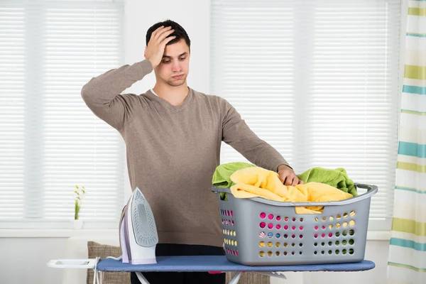 Cansado homem olhando para cesta de lavanderia — Fotografia de Stock