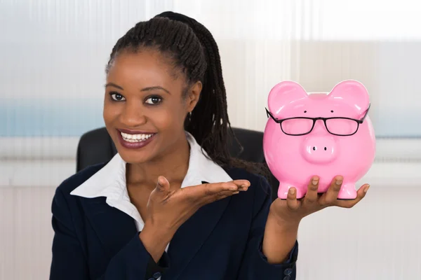 Piggybank を保持している実業家の笑みを浮かべてください。 — ストック写真