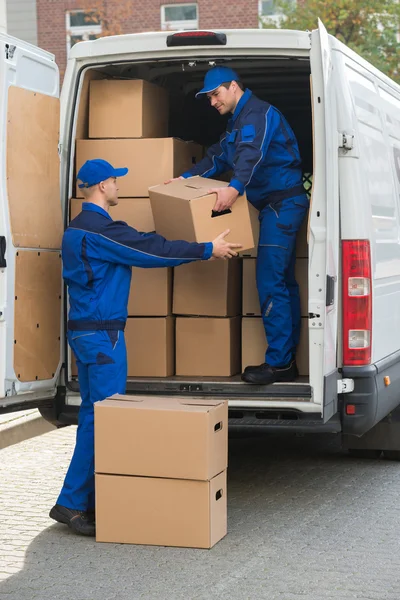 Homens de entrega descarregando caixas de papelão — Fotografia de Stock