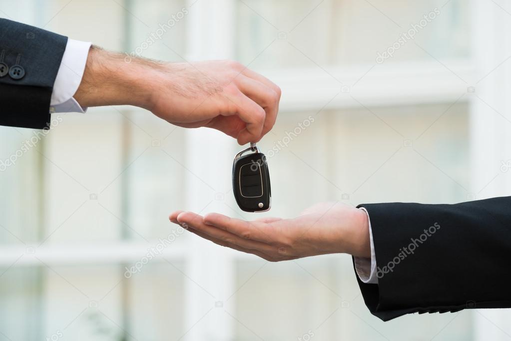 Car Dealer Giving Keys To Businessman