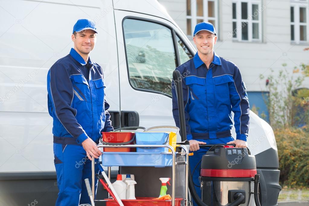 Happy Janitors Standing Against Truck