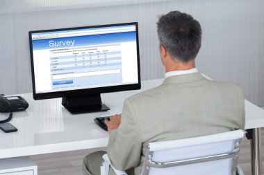 İşadamı bilgisayarda anket formu doldurma