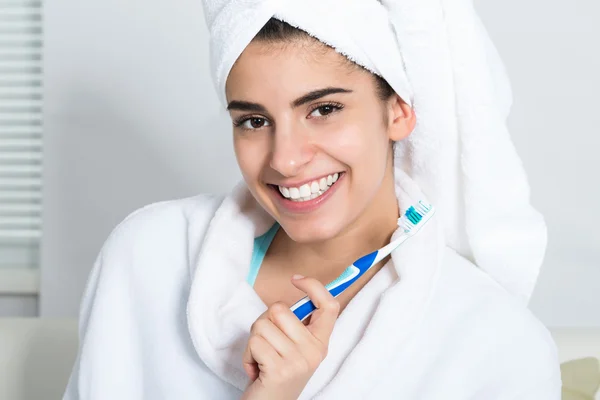 Mujer feliz sosteniendo cepillo de dientes en el baño —  Fotos de Stock