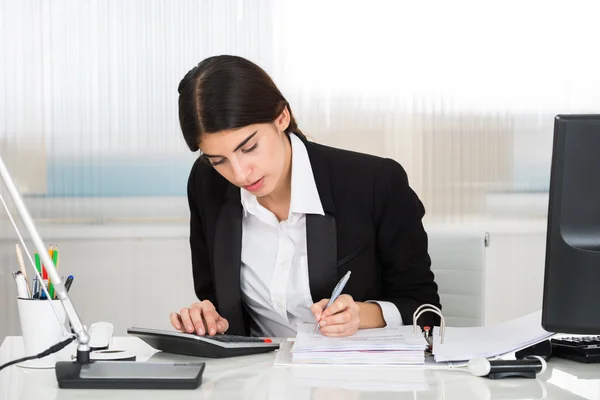 Buchhalter berechnet Finanzen mit Taschenrechner am Schreibtisch — Stockfoto