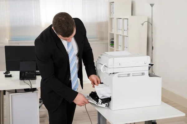 Businessman Removing Paper Stuck In Printer — Stock Photo, Image