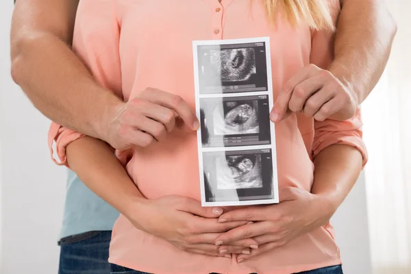 Esperando pareja con ultrasonido escanear en casa — Foto de Stock