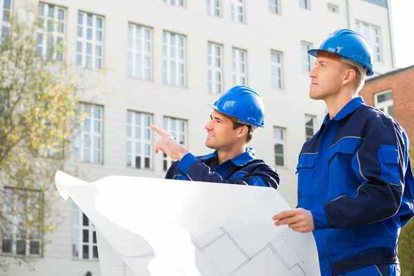 Arquitecto mostrando algo a sus colegas al aire libre — Foto de Stock