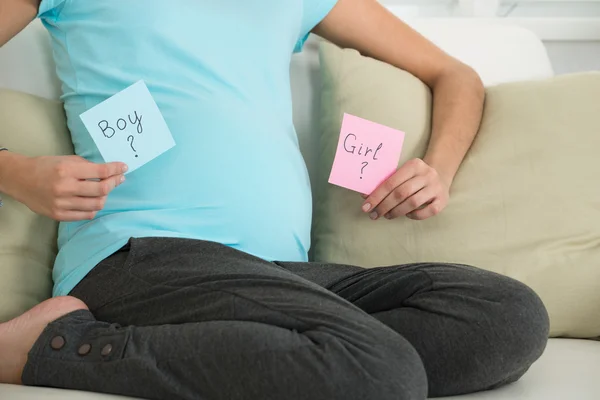 Mujer embarazada sosteniendo notas — Foto de Stock