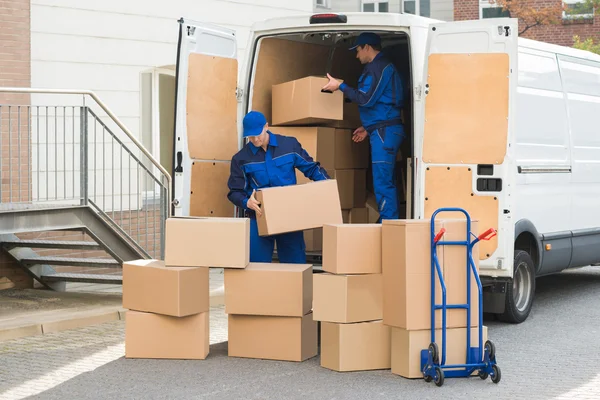 Homens de entrega descarregando caixas na rua — Fotografia de Stock