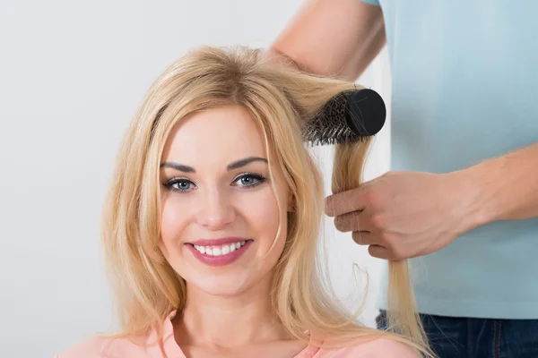 Hårstylist Brushing Woman 's Hair at Salon – stockfoto