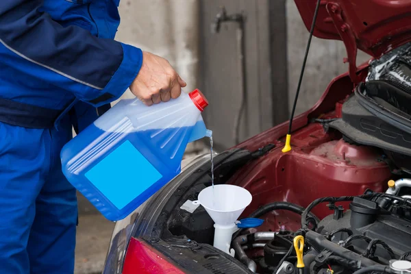 Voorruit ruitensproeiervloeistof gieten in auto — Stockfoto