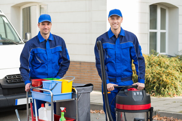 Happy Janitors Standing Against Truck