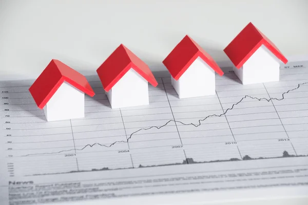 Huis modellen op financiële grafiek aan balie — Stockfoto