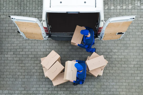 Homens de entrega descarregando caixas de papelão — Fotografia de Stock