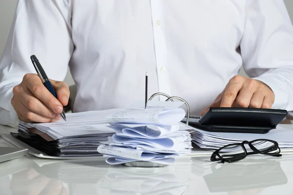 Businessman Calculating Invoice At Desk — Stock Photo, Image