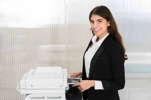 Mulher de negócios usando a máquina de fotocópia no escritório — Fotografia de Stock