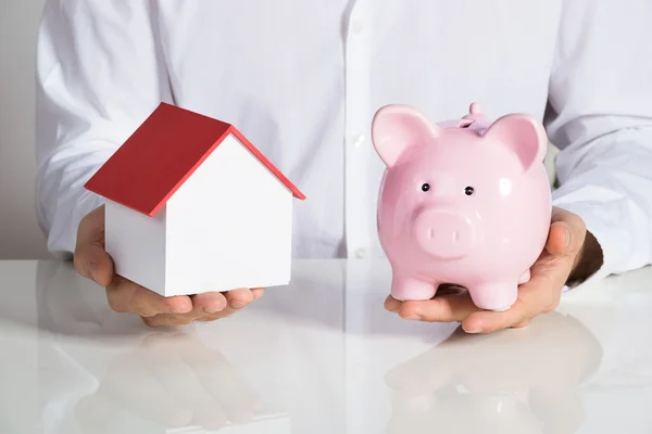 Businessman Holding House Model And Piggybank — Stock Photo, Image