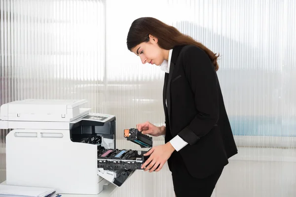 Бизнесвумен фиксирует картридж в принтере — стоковое фото