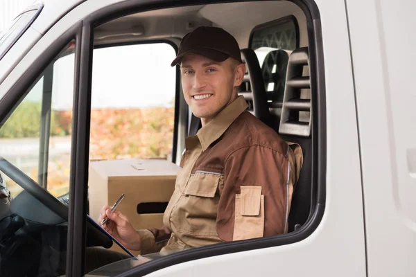 Uomo di consegna che fa lista di controllo nel camion — Foto Stock