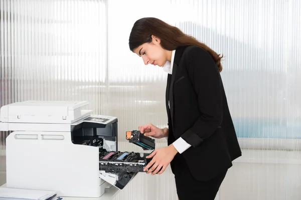 Geschäftsfrau fixiert Patrone in Drucker — Stockfoto