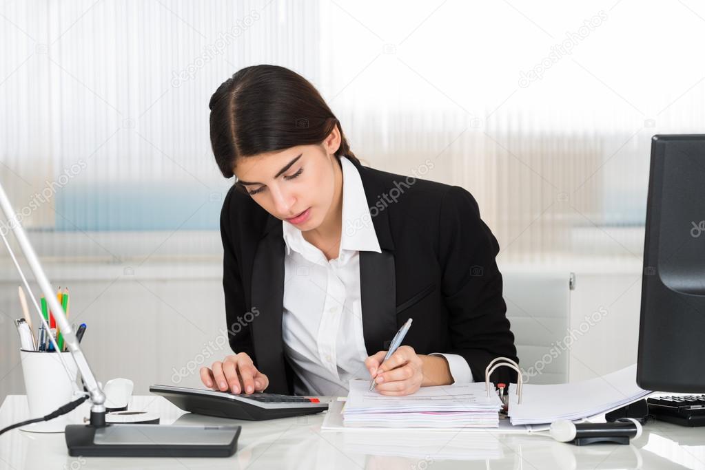 Accountant Calculating Finance With Calculator At Desk