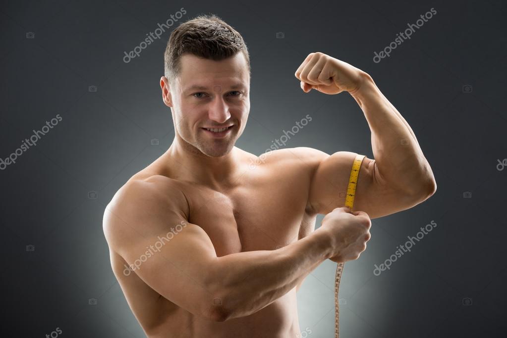 Happy Muscular Man Measuring Bicep Stock Photo by ©AndreyPopov 97125074