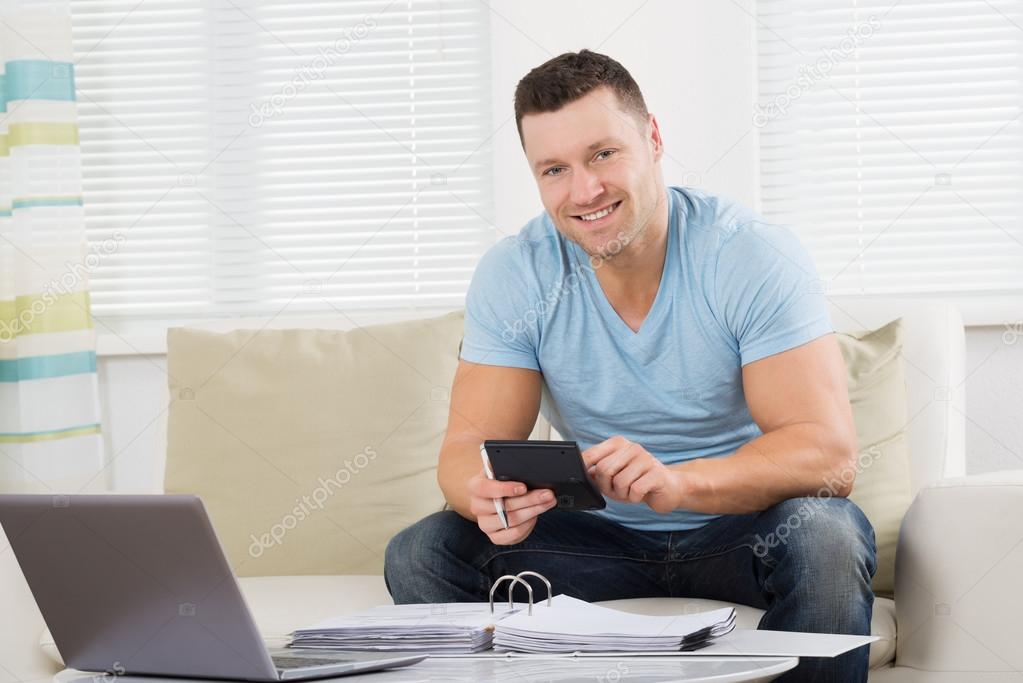 Man Calculating Home Finances At Table