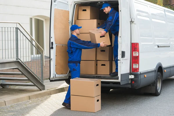 Homens de entrega descarregando caixas de caminhão — Fotografia de Stock