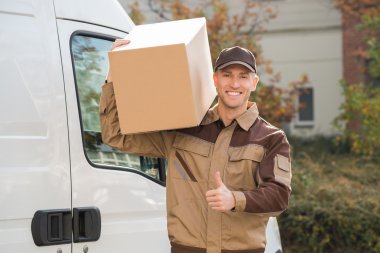 Karton kutu taşıyan teslimatçı.