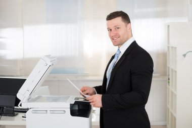 Businessman Using Photocopy Machine clipart