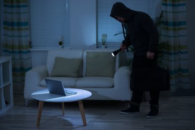 El feneri Laptop üzerinde tutarak soyguncu