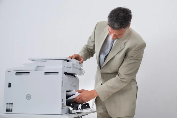 Biznesmen usuwanie papieru sklejone — Zdjęcie stockowe