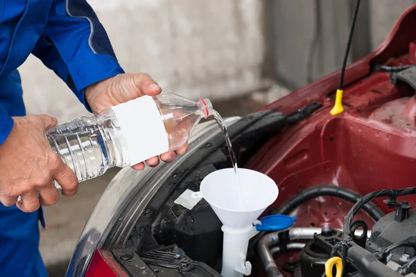 Arbetaren hälla vatten i tanken — Stockfoto