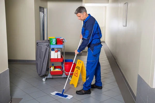 Male Worker With Broom Cleaning Corridor — Stock Photo, Image