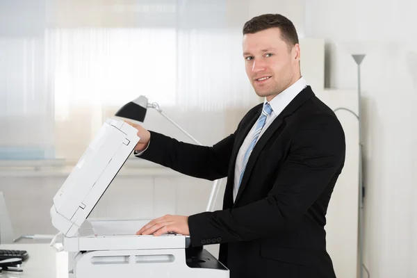 Homem de negócios usando máquina de fotocópia — Fotografia de Stock