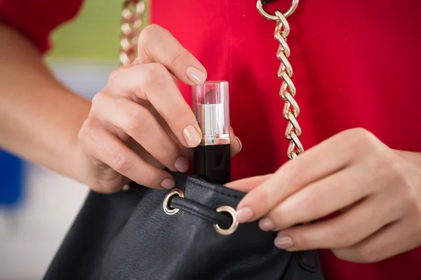 Mujer robando lápiz labial en el supermercado — Foto de Stock