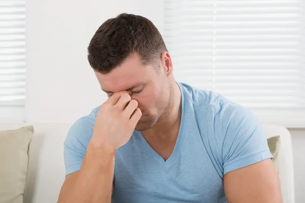 Mann mit Kopfschmerzen kneift sich die Nase — Stockfoto