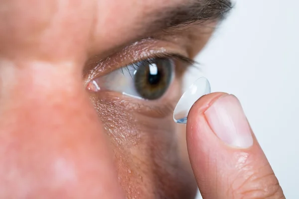 Людина кладе контактну лінзу в очі — стокове фото