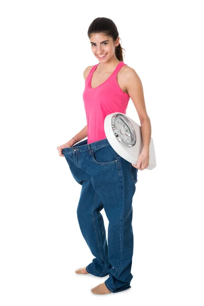 Улыбающаяся женщина со шкалой веса — стоковое фото