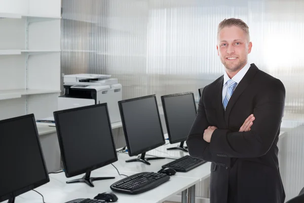 Jonge zakenman staande gekruiste armen — Stockfoto