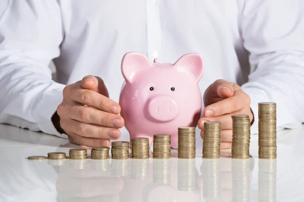 Empresario protegiendo Piggybank — Foto de Stock