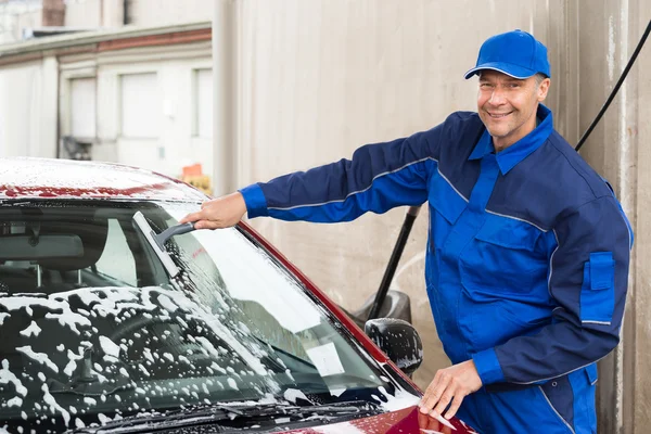 Arbeiter wäscht Windschutzscheibe von Auto — Stockfoto