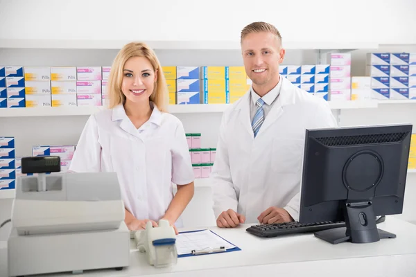 Farmacisti che sorridono al bancone — Foto Stock