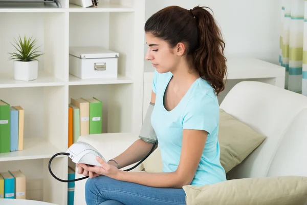 Mujer feliz comprobando la presión arterial — Foto de Stock