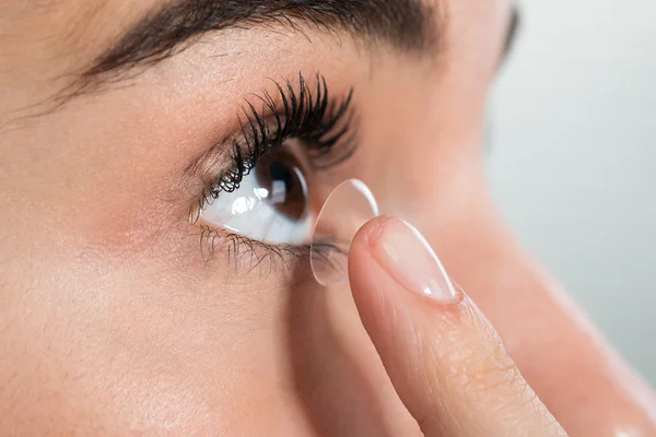 Mujer usando lentes de contacto en casa — Foto de Stock