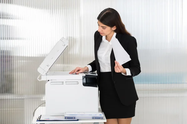 Femme d'affaires utilisant une machine à photocopier — Photo