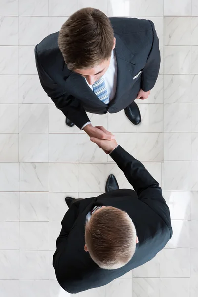 Hombres de negocios estrechando la mano en la oficina — Foto de Stock